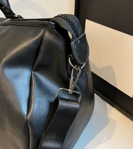 Details von robustem Metallhaken und Nylon-Schultergurt an schwarzer PU-Leder-Reisetasche