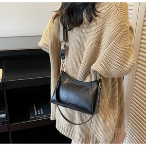 Détail du sac hobo noir en similicuir texturé avec bandoulière géométrique