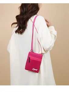 Vue arrière d'un mannequin portant un petit sac bandoulière rose en nylon sport