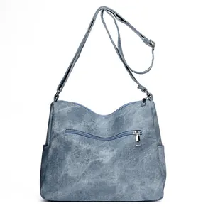Blue-gray washed canvas crossbody bag with adjustable strap and multi-pocket design