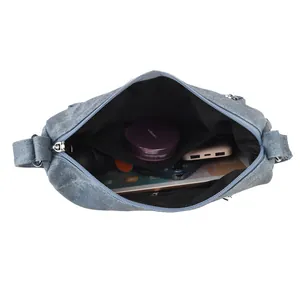 Blue denim crossbody bag interior view showing large capacity for tablet and daily items