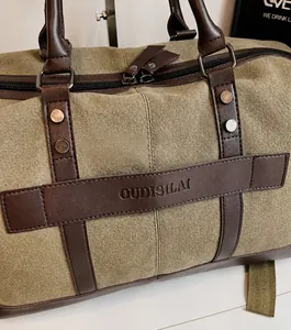 Primer plano de la bolsa de viaje de lona verde oliva con correas de cuero marrón y remaches