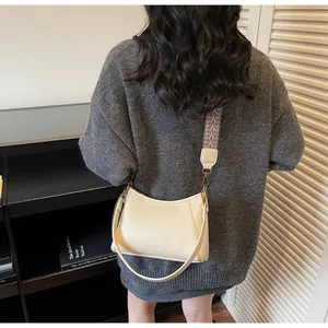 Détail du sac à main en cuir crème avec bandoulière ethnique porté par un mannequin