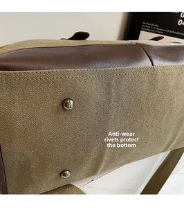 Dettaglio del fondo della borsa da viaggio in tela con angoli in pelle e rivetti metallici