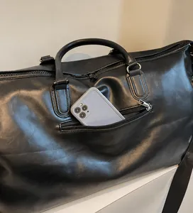 Detail der vorderen Reißverschlusstasche der schwarzen PU-Reisetasche mit Handy-Stauraum