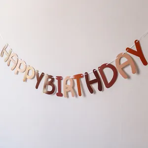 Detail of earthy tones Happy Birthday banner hung on wall for party decor