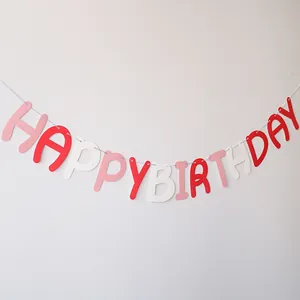Close-up of Happy Birthday bunting banner in red, pink and white felt for party decor