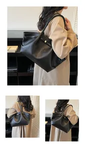 Detail of black pebbled leather tote bag with gold metal hardware and long shoulder straps