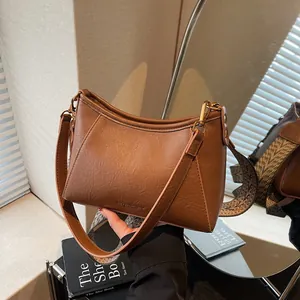 Sac à bandoulière en cuir marron de style vintage avec sangle jacquard à motifs