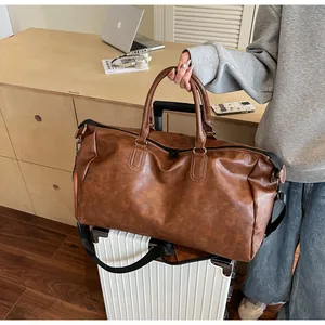 Braune Vintage-Reisetasche aus PU-Leder auf einem weißen Koffer in Lifestyle-Kulisse