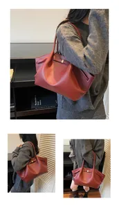 Macro shot of red-brown lychee grain leather tote bag with slim shoulder strap
