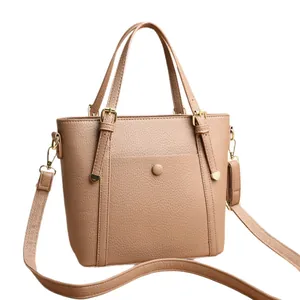 Minimalist tan pebbled leather tote bag with dual handles and gold-tone hardware
