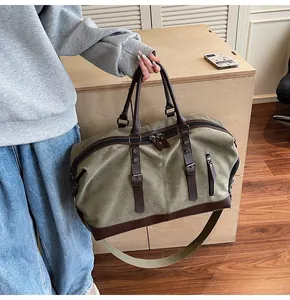 Detail of olive green canvas travel bag with leather trim and adjustable shoulder strap