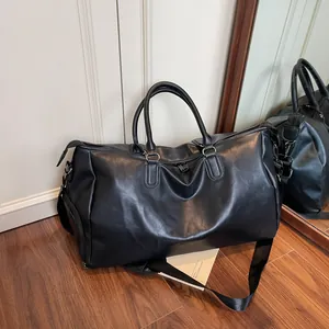 Große Reisetasche aus schwarzem Kunstleder mit Tragegurt im minimalistischen Interieur