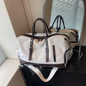 Large canvas travel duffel bag with shoe compartment and brown leather trim accents