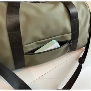 Detalle de bolsa de viaje verde militar con bolsillo frontal y cremallera impermeable