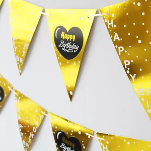 Detail der goldenen Geburtstagsgirlande mit Happy Birthday Text und schwarzem Herzmuster
