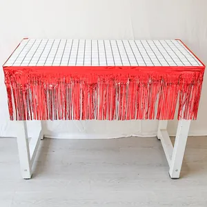 Détail de jupe de table en aluminium rouge à franges avec nappe à carreaux noir et blanc