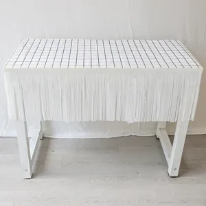 Détail de nappe à franges blanches avec motif à carreaux noir et blanc pour décor de fête