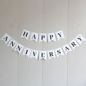 Detail of white swallowtail cardstock banner with black Happy Anniversary lettering