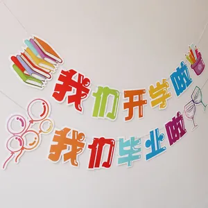 Colorful welcome back and graduation party banners hanging on white wall decorations