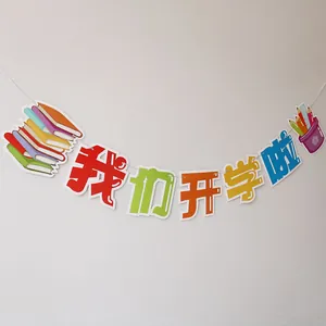 Close-up of school-themed decorative paper banner with colorful book and pen illustrations