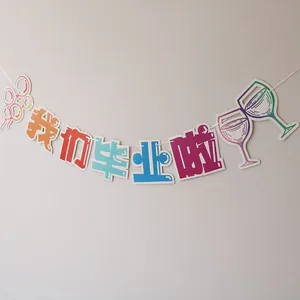 Close-up of colorful paper graduation banner with balloons and wine glass graphics