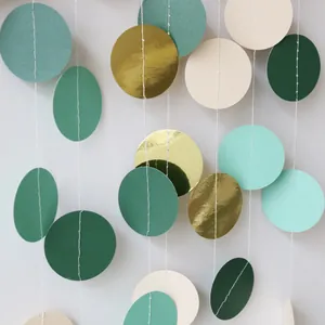 Detail of sage green and gold paper circle garland for forest party decorations