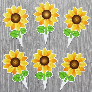 Vue détaillée de six décorations de gâteau tournesol avec pétales jaunes sur bois