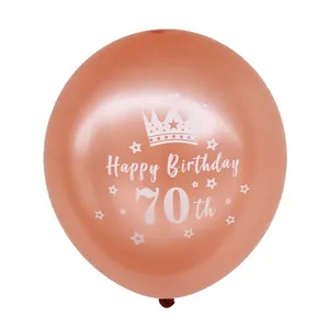 Detail van een metallic roségouden 70ste verjaardag ballon met witte kroon en sterren