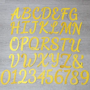 Dettaglio di lettere e numeri dorati glitterati per striscioni per feste su fondo legno