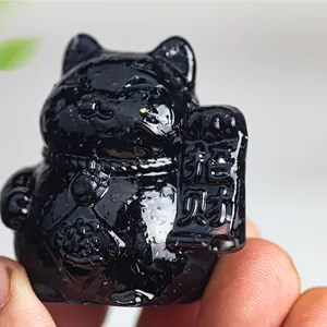 Detailed view of a black obsidian lucky cat figurine with lucky scroll and gold bell