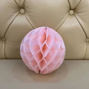 Detailed view of light pink paper honeycomb ball ornament for festive party decorations