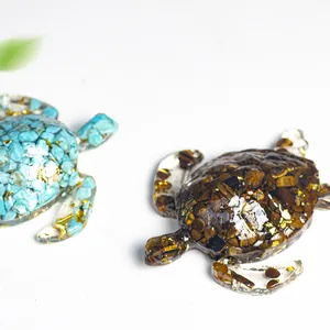 Figurines de tortue en résine avec cristaux naturels et feuilles d'or sur fond blanc