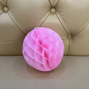 Detailed view of pink honeycomb paper ball decoration for party and wedding events