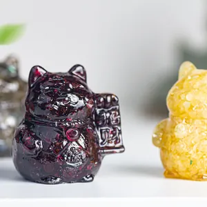 Detail of resin fortune cat figurines with natural amethyst and citrine crystal stones