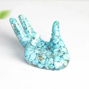 Vue macro d'une sculpture de main en résine avec pierres turquoises pour socle de cristal