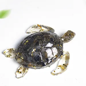 Détail d'une statue de tortue en résine avec cristaux noirs et éclats de feuilles d'or