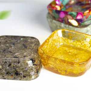 Makroaufnahme von Harzschalen gefüllt mit Naturkristallen und kleinen Muschelstücken