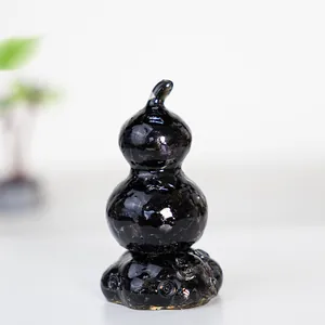 Detailed view of obsidian resin gourd ornament with crystal texture on a sleek gray base