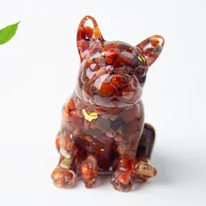 Dettaglio di una statuetta di bulldog in resina con pietre di agata rossa e foglia oro