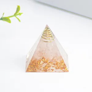 Detailaufnahme einer Orgon-Pyramide mit rosa Kristallstein und goldener Drahtspule
