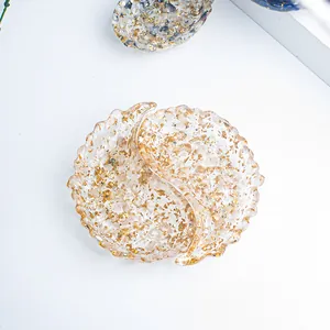 Close-up of heart-shaped storage tray with gold foil flakes in transparent resin material