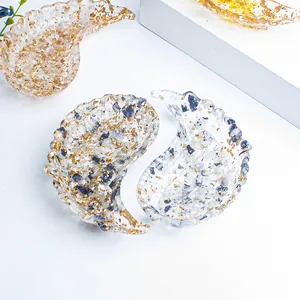 Macro view of crystal angel wing resin tray with embedded gold and silver foil flakes