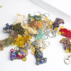 Resin bear keychains with colorful crystal stones and gears on a white display