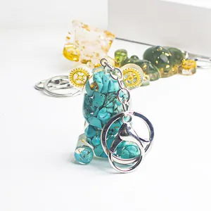 Detail of bear keychain with turquoise stone, gears, and gold foil in clear resin