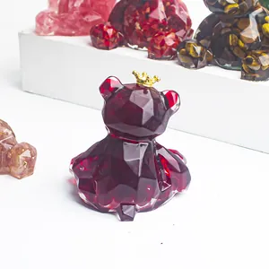 Close-up of a faceted red crystal resin bear figurine with a gold crown decoration