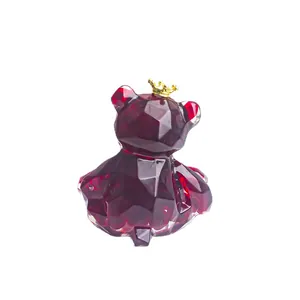 Faceted red crystal bear ornament with gold crown on white background for home or car decor
