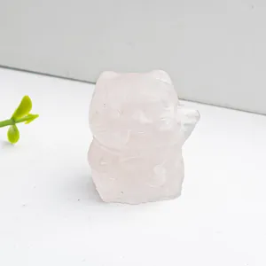 Makroaufnahme einer handgeschnitzten Winkekatze aus Rosenquarz mit lichtdurchlässiger Steinstruktur