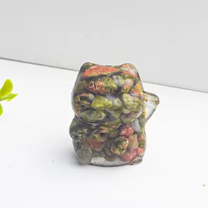 Detail einer Glückskatzen-Resin-Figur mit bunten Naturkristallen auf weißem Hintergrund